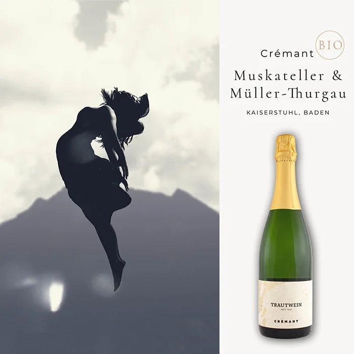 Cremant-Flasche vor eindrucksvollem Hintergrund, Silhouette einer tanzenden Frau, mystische Berge, bewölkter Himmel.