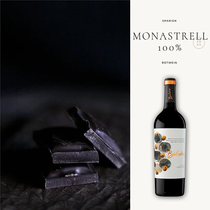 Dunkle Schokoladenstücke auf schwarzem Hintergrund neben einer Flasche spanischen Rotwein aus 100% Monastrell Trauben.
